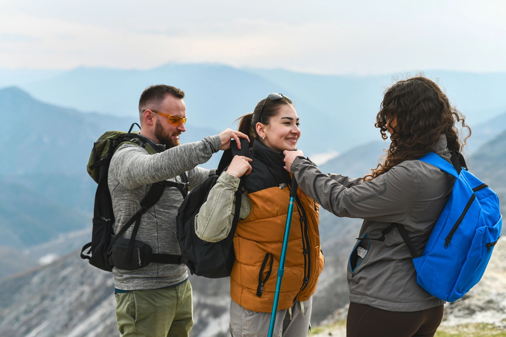 Group of hikers preparing gear in a mountain setting