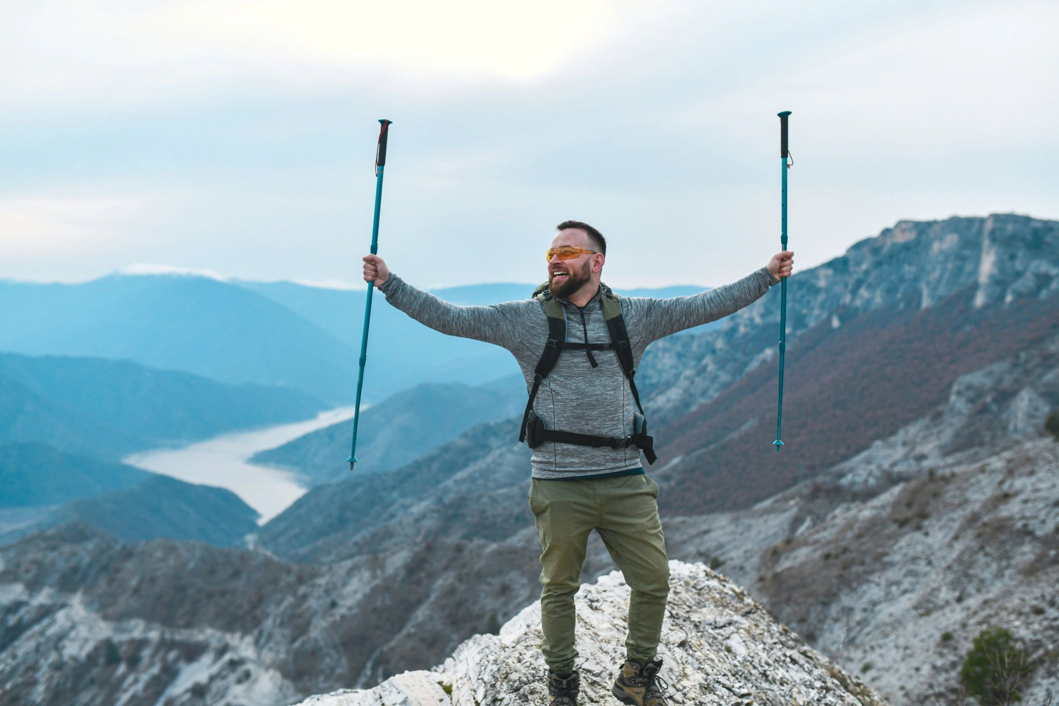 Adventurous hiker with trekking poles overlooking a mountain landscape